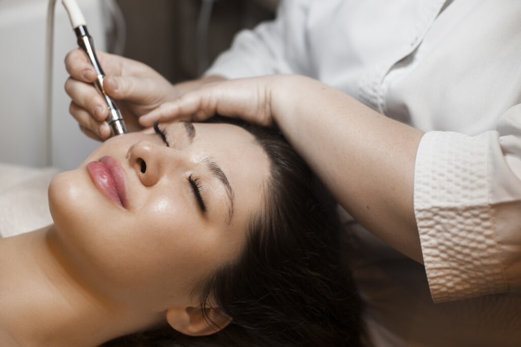close up side view portrait cute woman doing noninvasive microdermabrasion her face with dermapen by cosmetician
